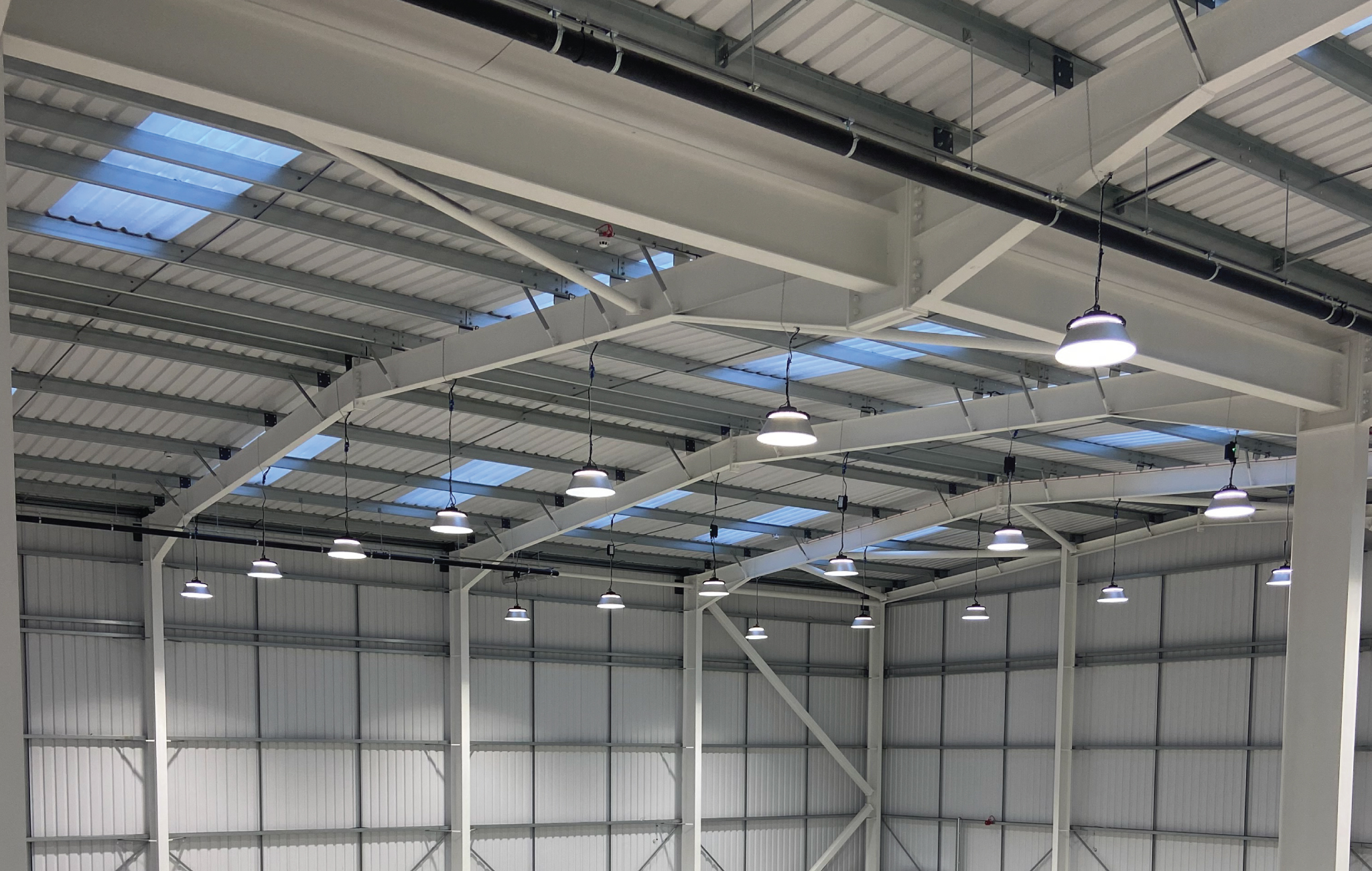 Occupancy and microwave sensor lighting controls automatically switching LED warehouse lighting based on movement